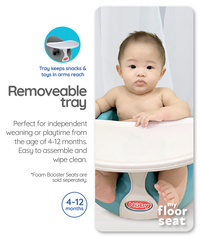 Astra Family A baby is sitting in a Nuby Floor Seat Tray with a removable tray.
