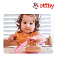 Astra Family A baby is sitting at a table with a bowl of peanut butter.