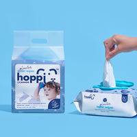 Astra Family Hand holding Hoppi Glacier Water Wipes 80's x 2 packs on blue background.