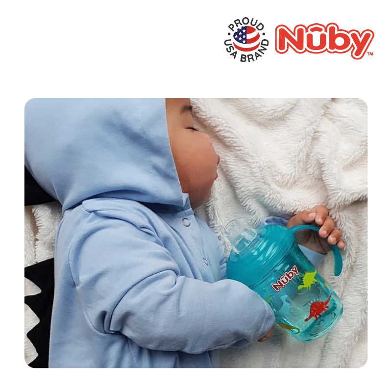 Astra Family A baby is sleeping in a blue hoodie with a blue cup.