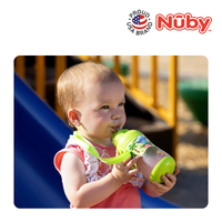 Astra Family A baby is holding a Nuby Tritan Flip It kindergarden water bottle in front of a slide.