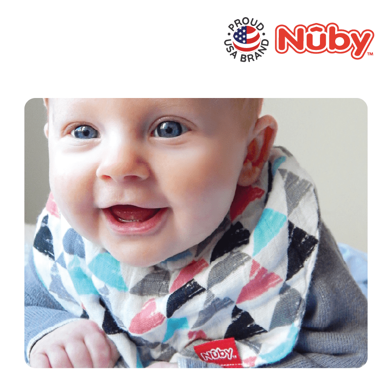 Astra Family A baby is smiling while wearing a nuby bib.