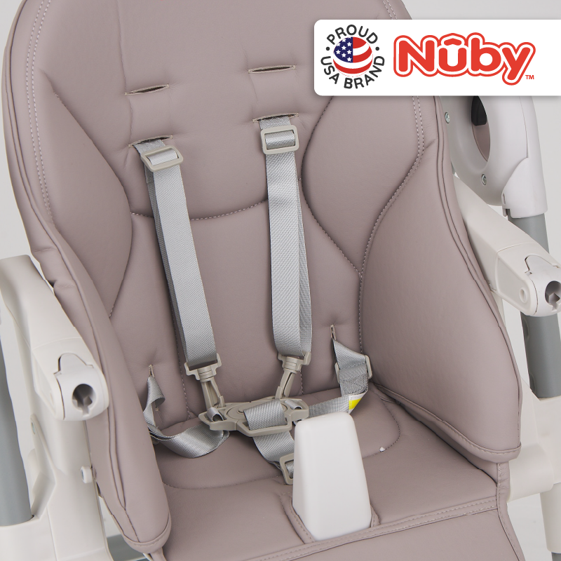Astra Family The nuby high chair has a grey seat and white straps.