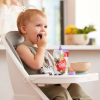 Astra Family A child is enjoying Bubs® Organic Berry and Banana Bircher Muesli in a high chair.
