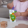 Astra Family A little girl is holding a pouch of Bubs® Organic Super Vegetable and Rice Congee, an imported organic baby food.