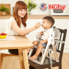 Astra Family A woman using a foldable Nuby Booster Seat to feed a baby.