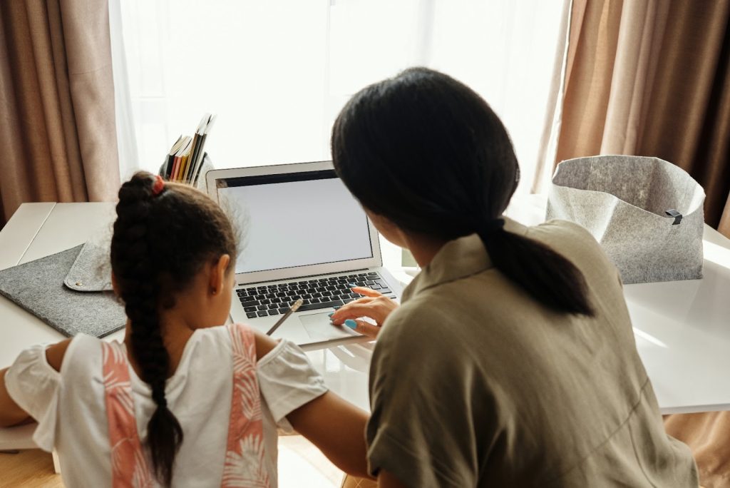 Astra Family A woman and her daughter implementing 8 tips on creating an effective learning environment while working on a laptop at home.