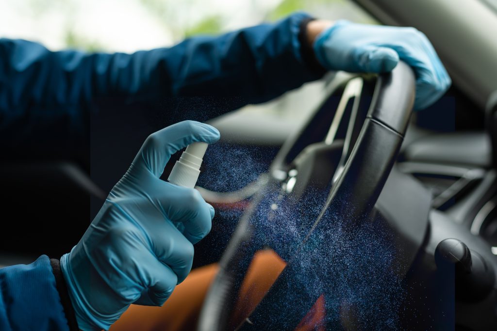 Astra Family A person is sanitizing a car with blue gloves.