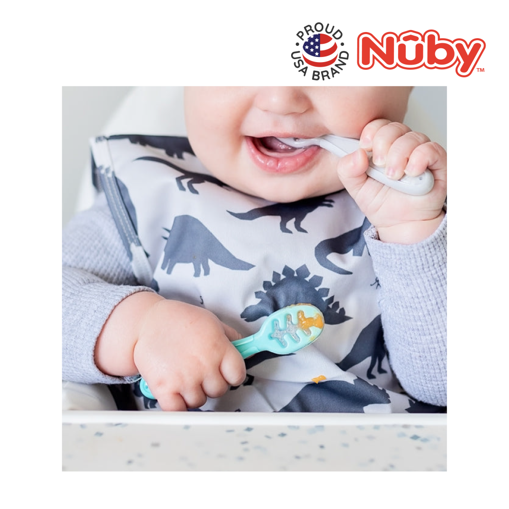 Astra Family A baby is using the Nuby 3 Stage Dipping Spoons to brush his teeth in a high chair.